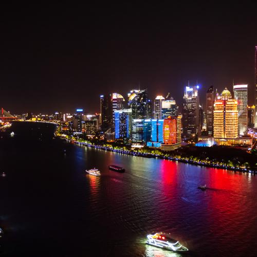 View of the Huangpu River in Shanghai at night. Buildings shines with bright colors. The oriental pearl tower can be seen