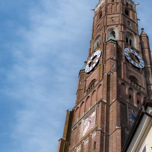 Bell tower of St. Martin in Landshut against blue sky with some white clouds